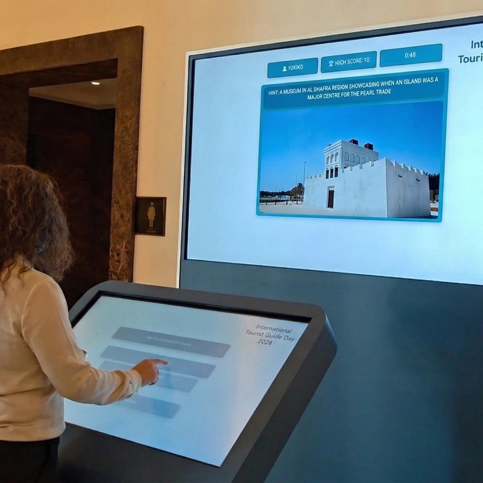 Multi-screen interactive UAE landmark guessing game display with custom branded interface for immersive event activation and digital tourism engagement.